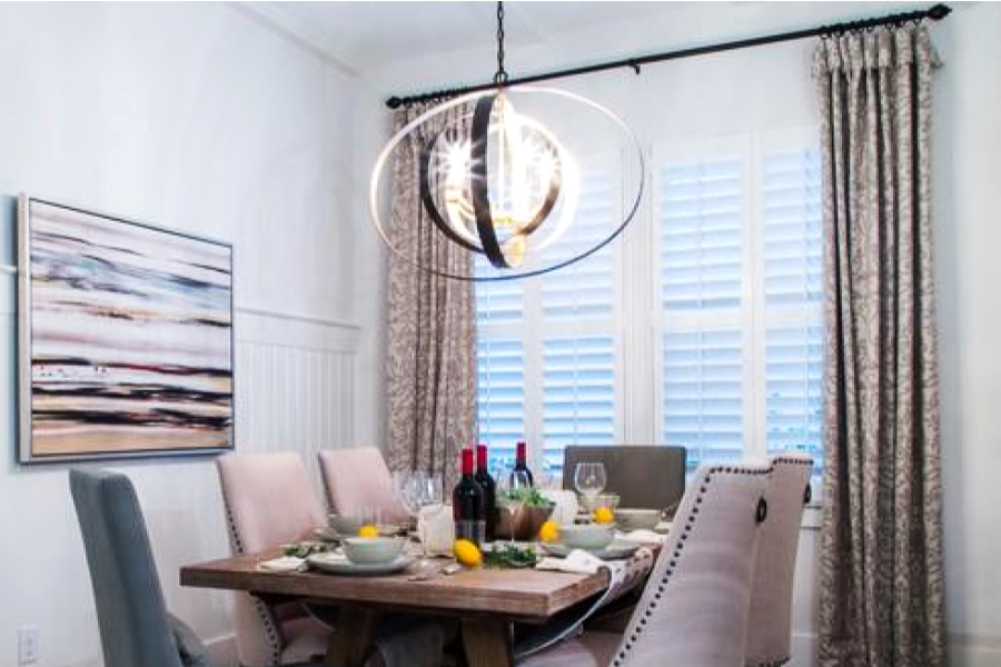 A modern light fixture hanging over a dining room table