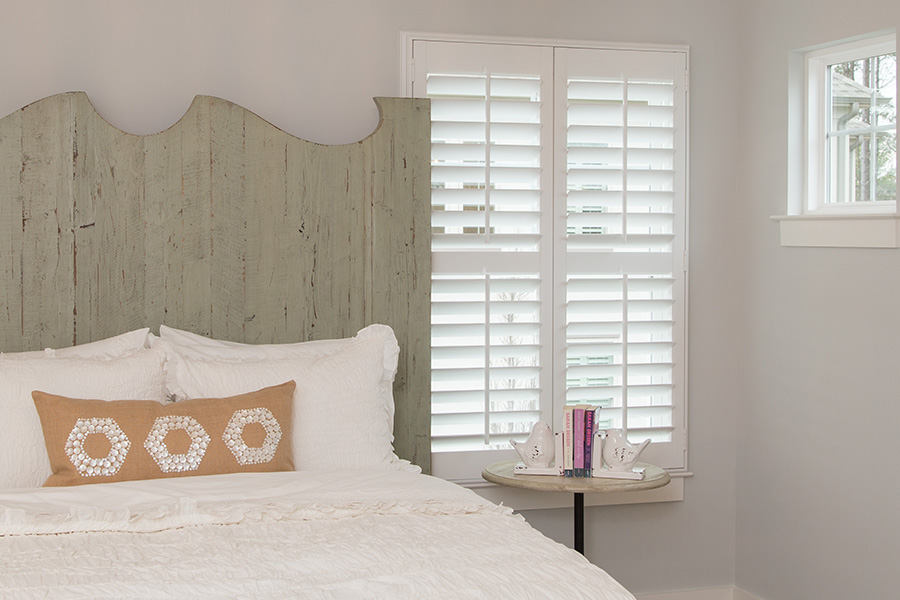 Bedroom with white Polywood shutters.