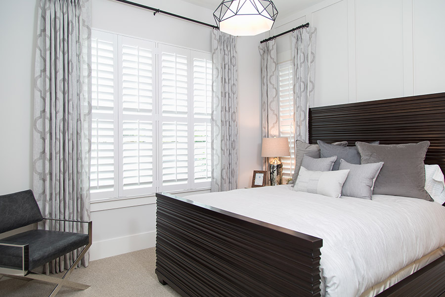 Bedroom with a lot of natural light from white Polywood shutters.