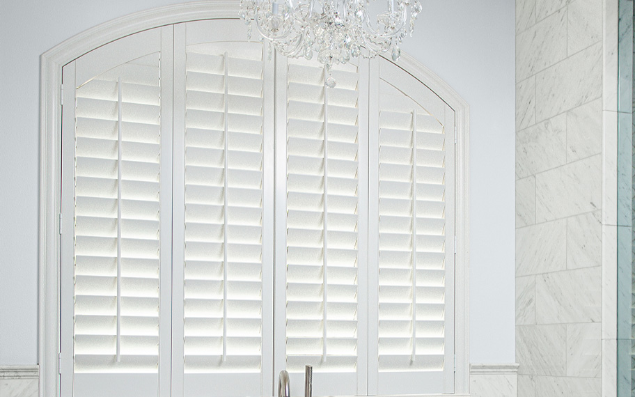 Arched white shutters in a bathroom