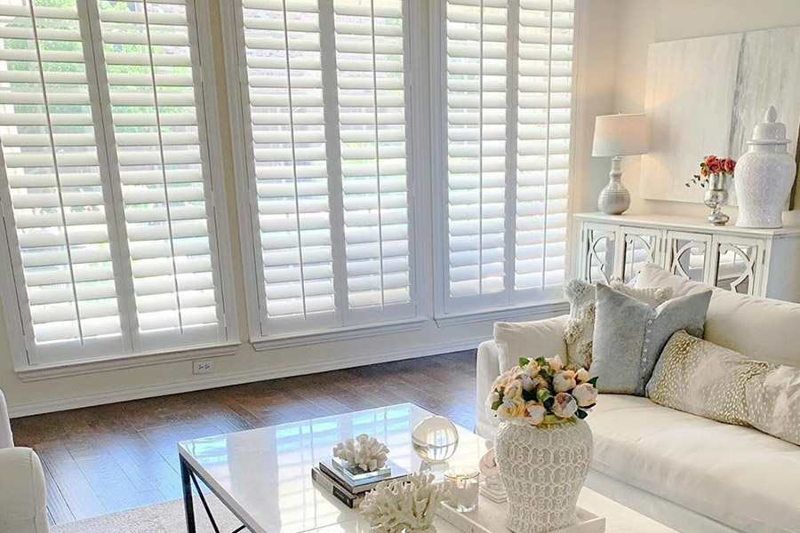 White Polywood shutters in a large living room window.